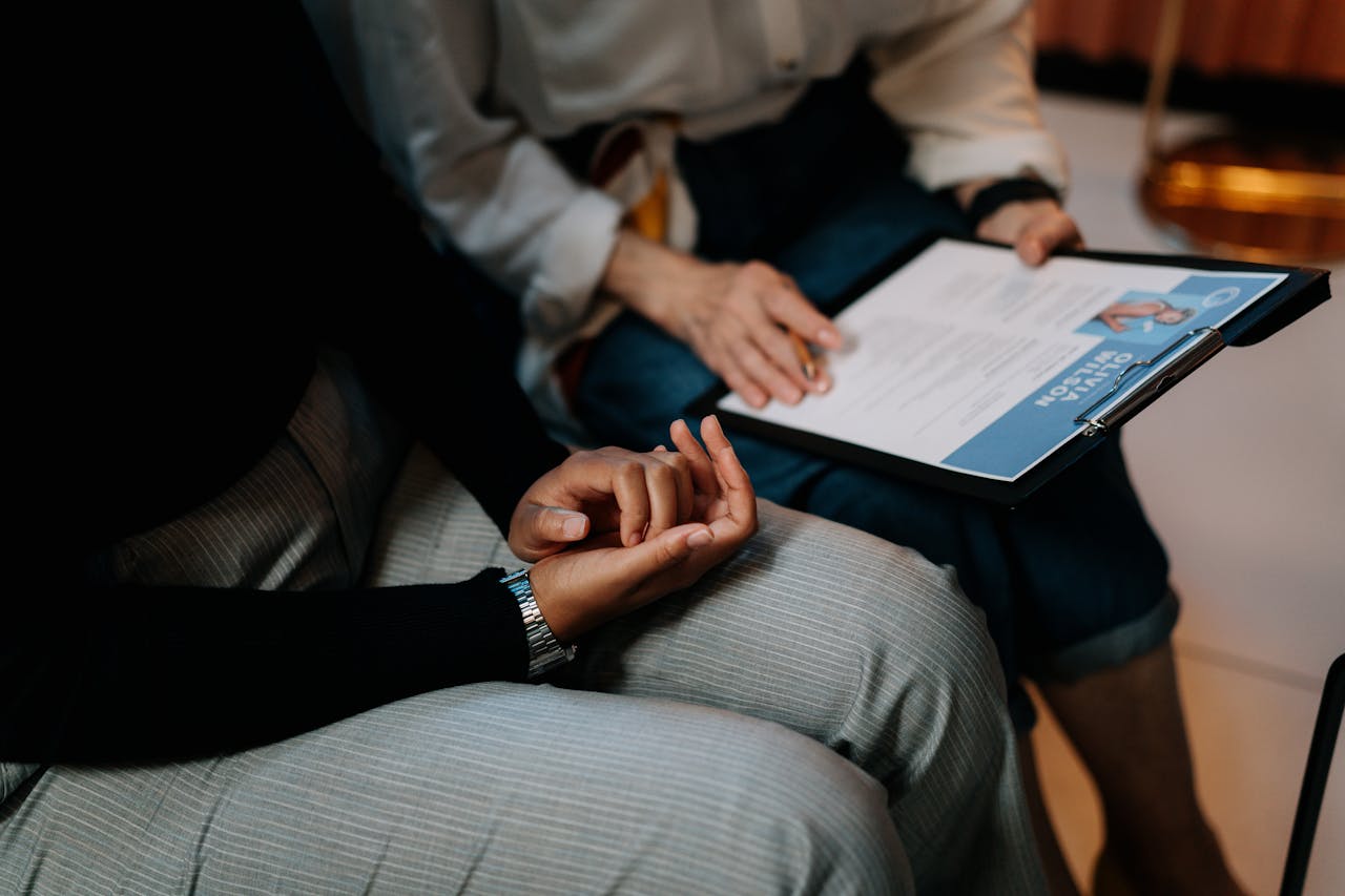 person-in-white-long-sleeve-shirt-holding-a-clipboard-with-resume-5989933